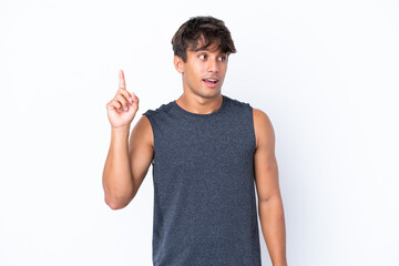 Young sport caucasian man isolated on white background intending to realizes the solution while lifting a finger up