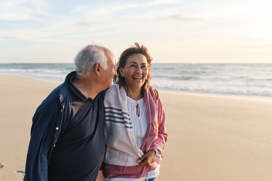 Happy senior woman enjoying vacation with man at beach