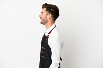 Restaurant caucasian waiter isolated on white background laughing in lateral position