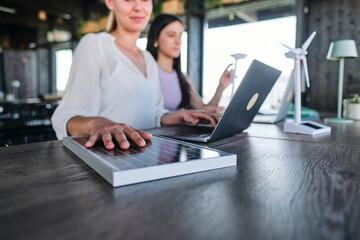 Hand of young woman testing solar panel while working at coworking space