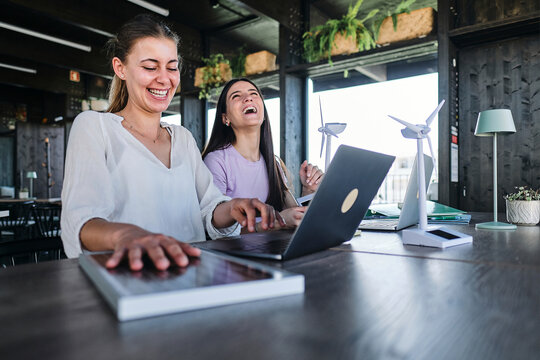Two young women working together on sustainable resources project at coworking space