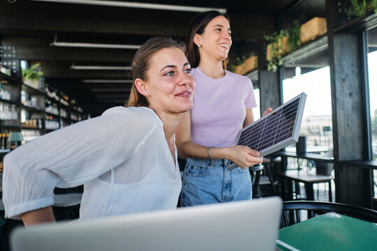 Two young women working together on sustainable resources project at coworking space