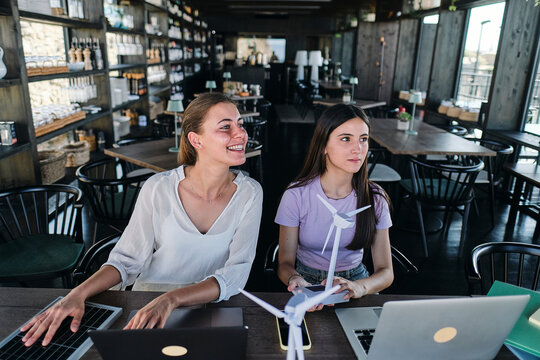 Young women testing solar panel while working at coworking space