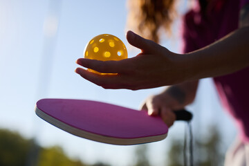 Pickle ball player serving a ball with a paddle racquet