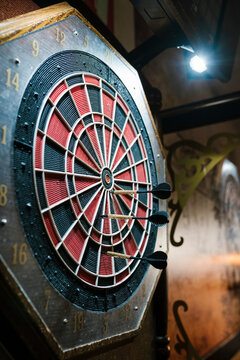Darts hitting target on dartboard in bar