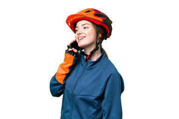 Young cyclist woman over isolated chroma key background keeping a conversation with the mobile phone
