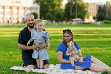 mom and dad playing with their kids on the lawn outdoors, spend time together