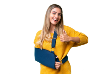Young Uruguayan woman with broken arm and wearing a sling over isolated background giving a thumbs up gesture