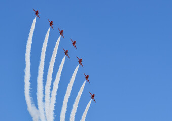 british raf red arrows falcons aerobatic team fighter jet with blue skies in formation with white smoke trail air show display teams manoeuvre - obrazy, fototapety, plakaty