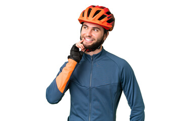 Young cyclist man over isolated chroma key background thinking an idea while looking up