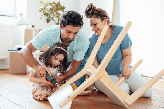 Mother with father and daughter fixing chair at home