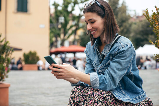 Smiling woman using mobile phone