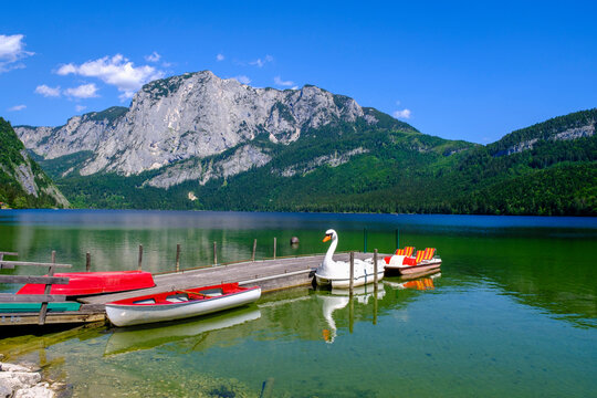 Austria, Styria, Rowboats moored along jetty on shore of Lake Altaussee in summer