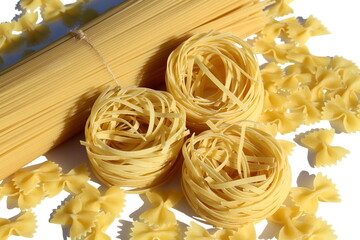  Long spaghetti and nests lie on a white background.