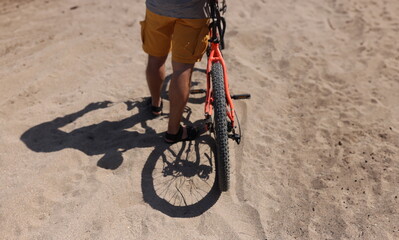 Rear wheel of mountain bike and rider leg. Rear shot of mountain bike on dirt road and closeup of mountain bike tire