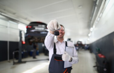 Fototapeta premium Auto mechanic holds clipboard and car keys. Quality auto repair services