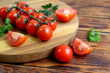 Cherry tomatoes lie on a wooden board.