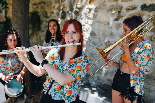 Smiling artist playing western concert flute with folk group