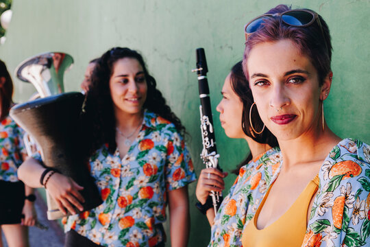 Hipster woman with folk group holding musical instruments