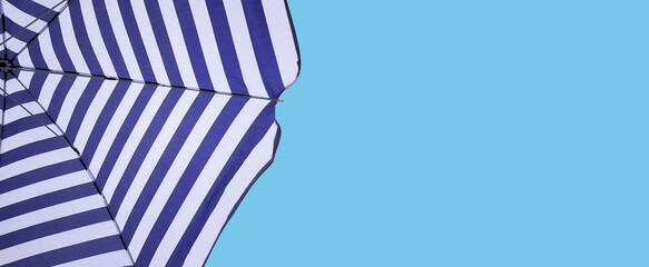 Striped beach umbrella on blue sky background