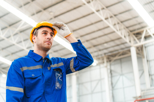 Professional male caucasian engineer or manufacturing worker man person in factory portrait, smart industry business manager occupation job with safety helmet for construction work, machinery foreman