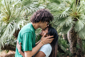 Affectionate boyfriend kissing girlfriend in park