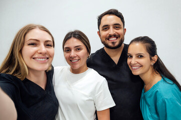 Smiling dentists in front of wall at clinic