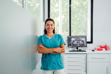 Happy dentist with arms crossed in clinic