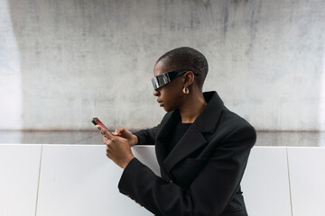 Young woman wearing smart glasses using smart phone at metro station