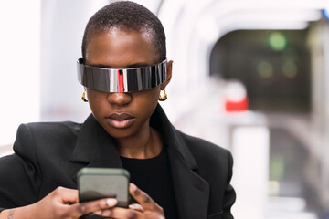 Young woman wearing smart glasses and using mobile phone