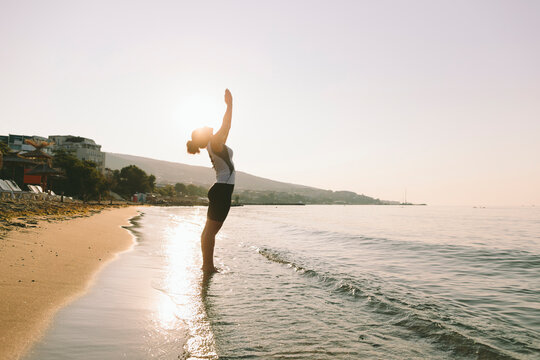 Woman with hands clasped practicing yoga on sunny day at beach