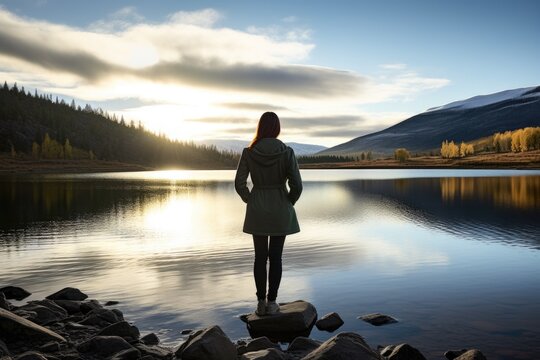 Woman Standing Near A Scenic, Tranquil Lake