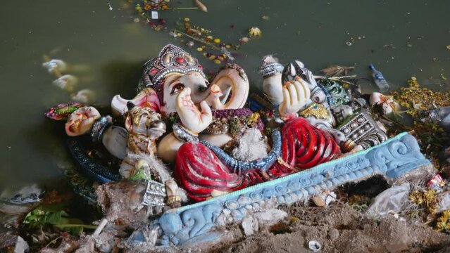 ganesh statue close up shot in the lake with water after visarjan