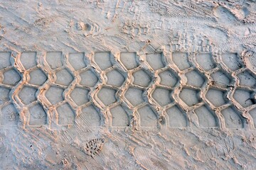 embossed trail excavator tracks on the wet sand. texture of sand.