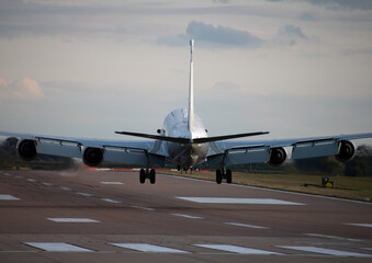 military raf rivet joint boeing RC-135 airplane in flight landing down on runway in sunset tail - obrazy, fototapety, plakaty