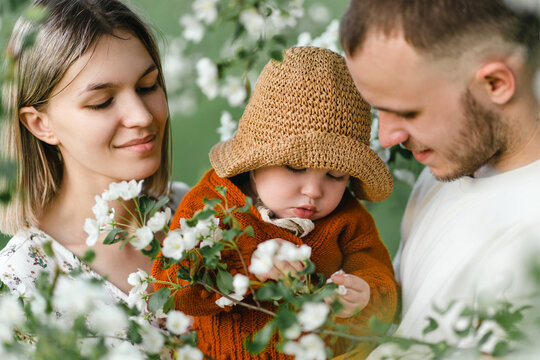 Smiling parents with child spending leisure time in garden