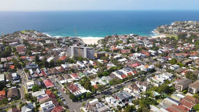 Aerial drone view of homes and streets above the beachside suburb of Tamarama, looking toward Tamarama Beach in east Sydney, NSW Australia on a sunny morning