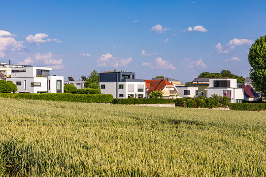 Germany, Baden-Wurttemberg, Ludwigsburg, Green summer field with modern suburban houses in background