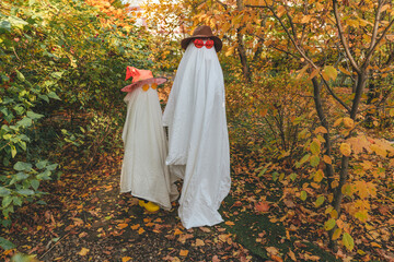 Girls wearing halloween costumes standing amidst plants in garden