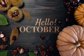 Hello October background: chestnuts and pumpkins on a wooden table