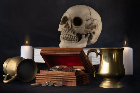still life image with skull money chest and candles