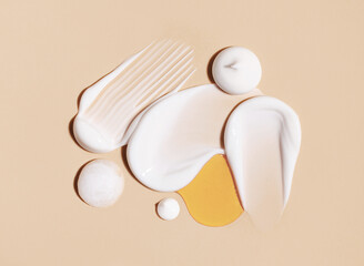 cosmetic smears of creamy texture on a beige background