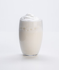 milk with foam in glass of milk on white background