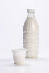 fresh milk in plastic bottle with yogurt jar on white background