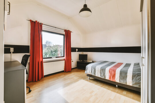 Bedroom with bed in front of window and curtains at home