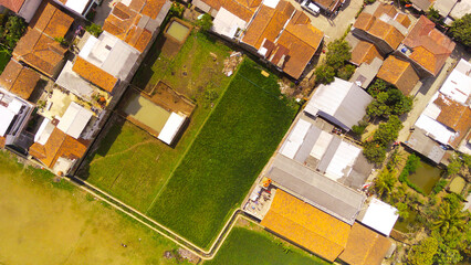 Aerial Photography. Aerial Drone view landscape view of the border between housing and rice fields, Cikancung - Bandung, Indonesia. Housing and rice fields are side by side - obrazy, fototapety, plakaty