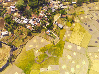 Aerial Photography. Aerial Drone view landscape view of the border between housing and rice fields, Cikancung - Bandung, Indonesia. Housing and rice fields are side by side