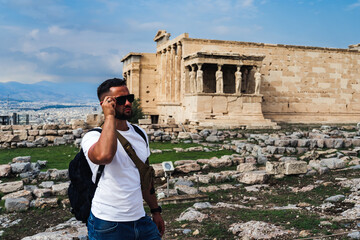 Male tourist in sunglasses near the Parthenon in Greece.