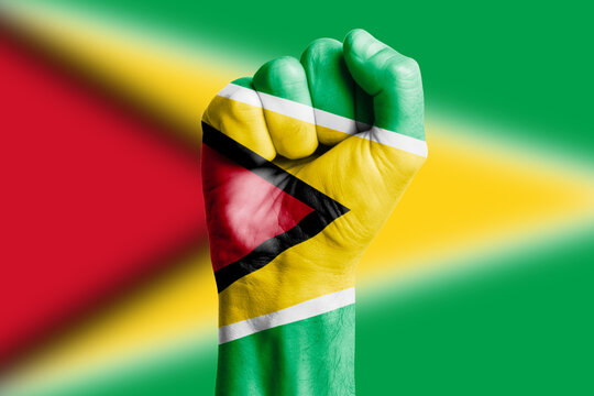 Man hand fist of GUYANA flag painted. Close-up.