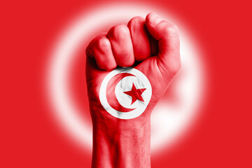 Man hand fist of TUNISIA flag painted. Close-up.